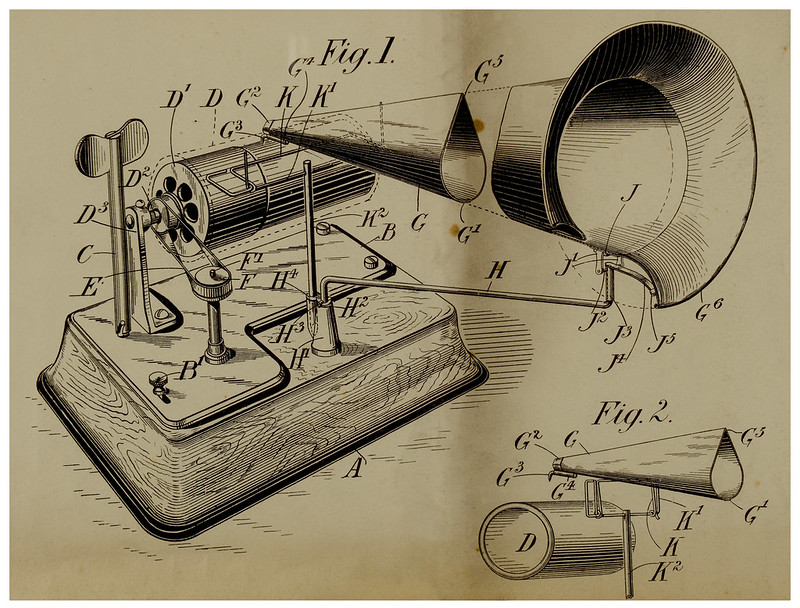 A drawing of an early sound amplification device with a
                wooden base, pulleys, a drum, a crank, a speaker cone, and
                labels coded with letters of the alphabet