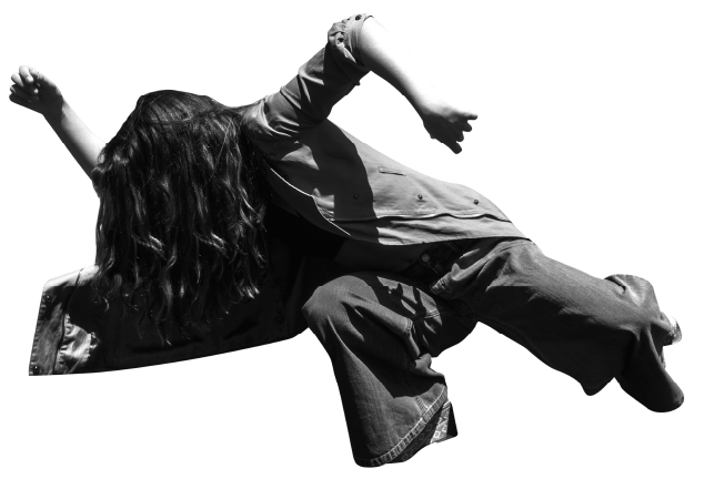 A dancer wearing denim spinning with arms outstretched and hair covering her face