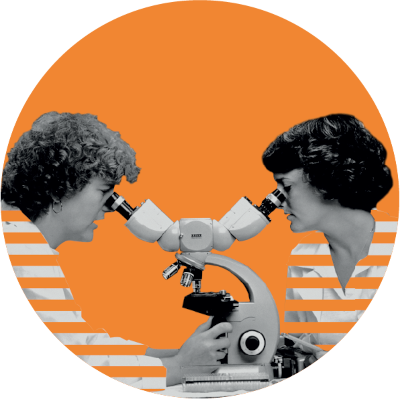 Two women look into a microscope together