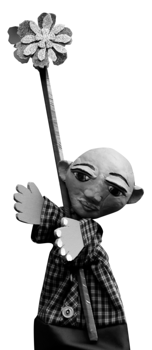 A puppet with clay face and cardboard hands holding a stick with a flower on the end