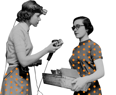 Two women hold archival objects in 1950s-era photo